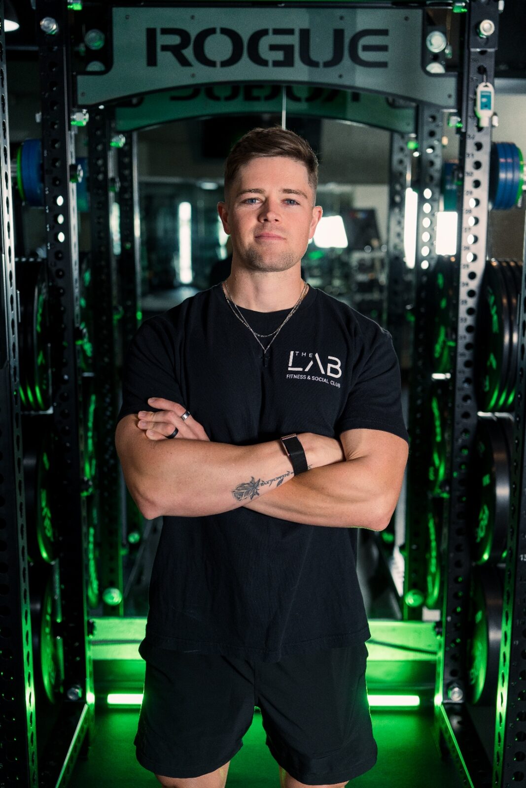 Dylan standing in a power rack, arms crossed